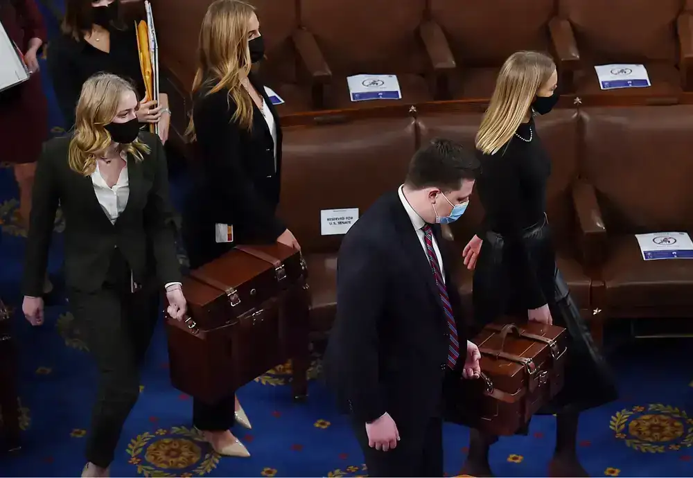 Congressional aides carry boxes with certified elector votes